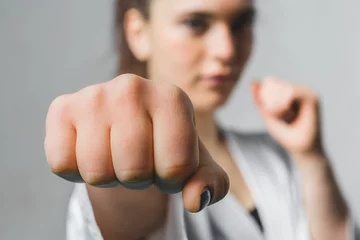 Fototapete Kampfkunst Junge Frau, die mit Karate-Kampfkunst übt