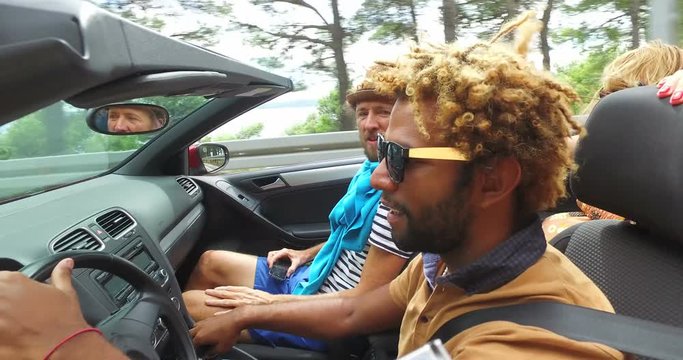 Black handsome man driving his friends in convertible