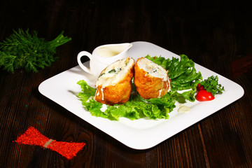Baked chicken on white plate. Wood background.