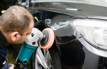 Man on a car wash polishing car with a polish machine