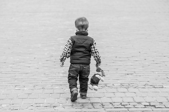 Lost Boy Outdoors On A Street Holding A Teddy Bear