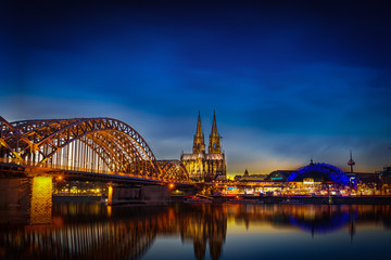 Köln beleuchtet vom Rheinufer aus mit Hohenzollernbrücke