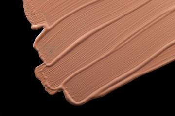 Smudged liquid foundation isolated on black