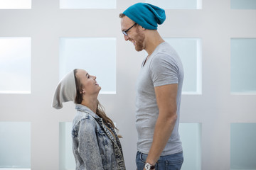 Short woman and tall man laughing at each other