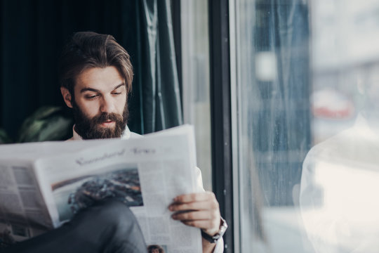 Businessman reading newspaper at cafe