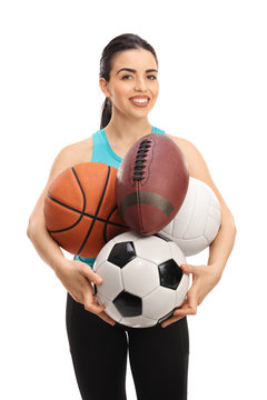 Young woman holding different kinds of sports balls
