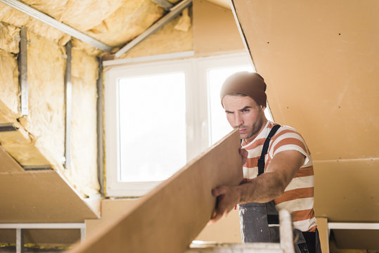 Young man checking plank on construction site