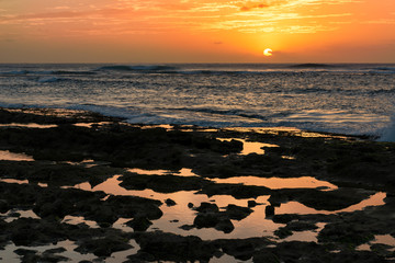 Fototapeta na wymiar Sunset by rocky tide pools in Waianae, Hawaii