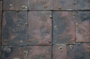 old rusty metal plates nailed up with wrought tacks