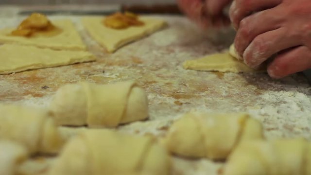 Woman working with dough. making homemade croissants