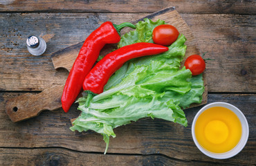 .Salad, pepper, green onion,  oil, salt on a rustic wooden table.