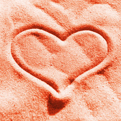 Red heart on the sand