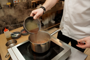 Restaurant chef is cooking soup