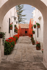 View through an arch to typical street and buildings in historic Santa Catalina Monastery, Arequipa, Peru