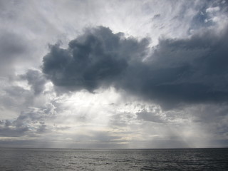 Monotone of dark cloud with rays of sunlight