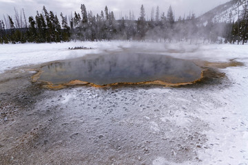 A pool of hot waters in Black sand basin, winter landscape, Yellowstone National Park