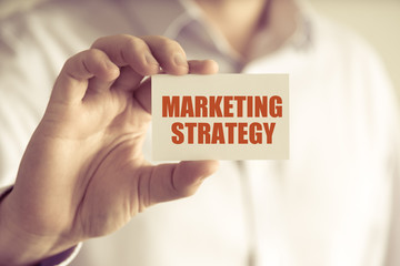 Businessman holding MARKETING STRATEGY message card