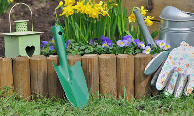 accessoires de jardin devant bordure en bois fleurie