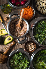 Buckwheat, carrots, avocados, grass in a bowl of water top view