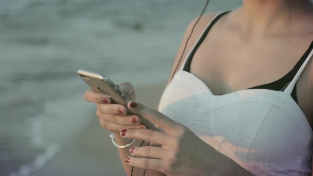 Woman with smartphone on the shore