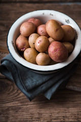 Raw potatoes red and white in bowl on a napkin