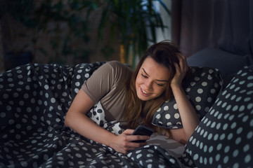 Obraz premium woman using smart phone / laptop at home lying / sitting in bed