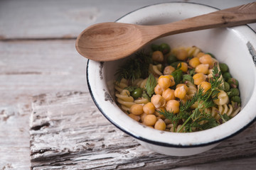 Salad with fusilli, chickpeas and peas in a white bowl