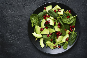 Avocado salad with baby spinach and pomegranate.Top view with copy space.
