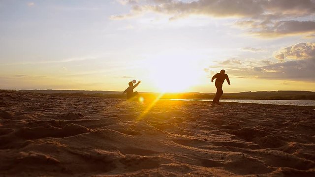 Training men in volleyball on beach in sun, beach volleyball on sand on summer evening