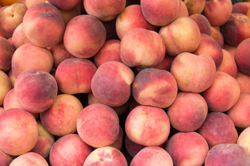 juicy red peaches lie on a pile