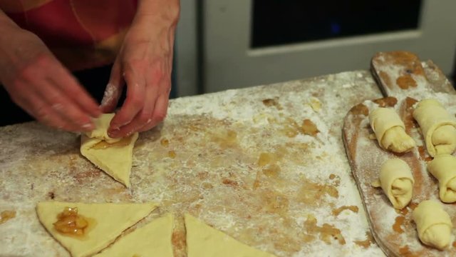 Woman working with dough. making homemade croissants