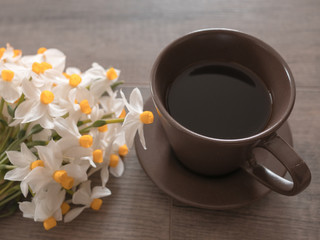 White daisy flowers and coffee on wooden