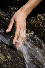 mains de femme dans une cascade d'eau