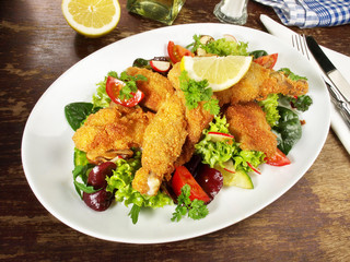 Backhendl mit Zitrone auf Salat