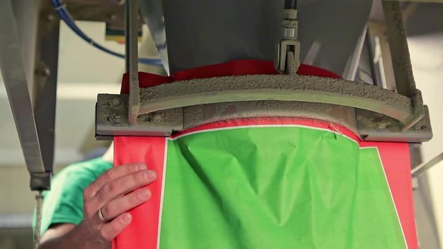 Packing for animal feed in bags man at the factory for the production of animal feed