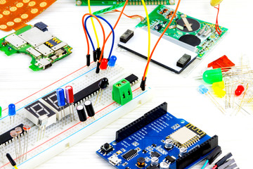 Microcontrollers, chips, resistors and light-emitting diodes on white desktop of hardware engineer....