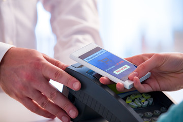 Wireless payment using smartphone and NFC technology. Close up. Customer paying with smart phone in pharmacy. Close Up shopping