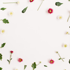 Frame wreath with red and white wildflowers, green leaves, branches on white background. Flat lay, top view. Flower background.