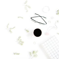 Coffee cup, notebook, glasses, green branches and female accessories on white background. Flat lay, top view