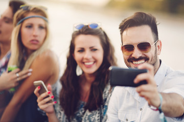 Party people taking selfies during summer festival