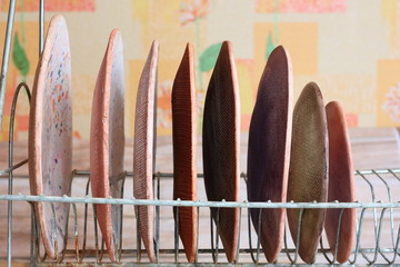 Multicolored ceramic handmade pottery plates in metal stand for plates. Tableware in the interior