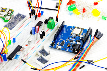 Microcontrollers, chips, resistors and light-emitting diodes on white desktop of hardware engineer....