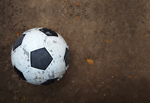 Old soccer ball on ground, soft focus
