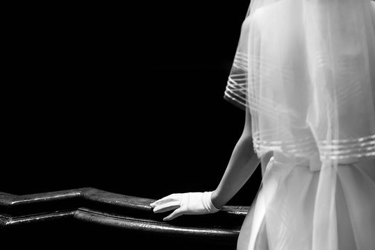 elegant gorgeous bride hand in silk glove on wooden handrail of old stairs. unusual luxury wedding couple in retro style. black white photo