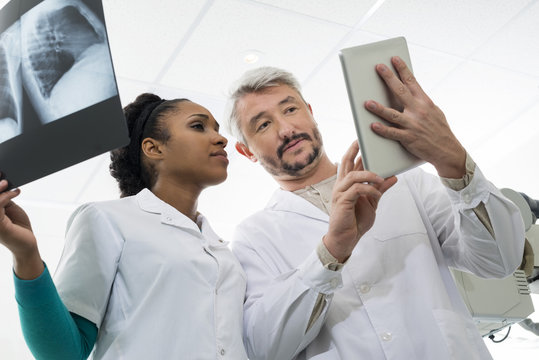 Doctors With X-ray Using Digital Tablet In Hospital