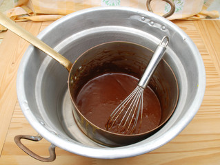Melted chocolate in a double boiler in copper pot