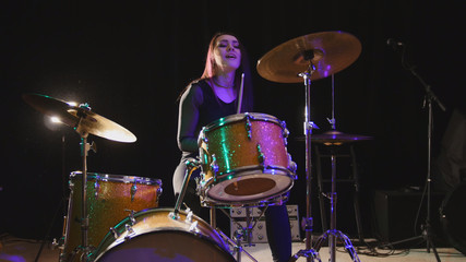 Fototapeta na wymiar Teen rock music - attractive girl percussion drummer perform music break down