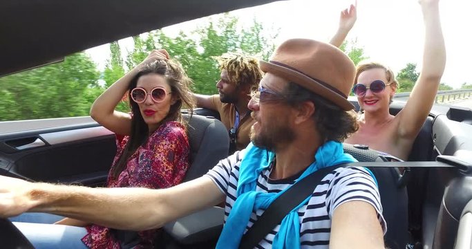 Bearded hipster man with a hat driving his friends in convertible