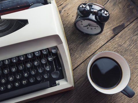 top view photo of vintage typewriter with  cup of coffee, on wooden table. retro filtered image