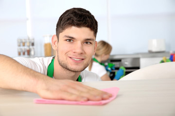 Young man cleaning kitchen table